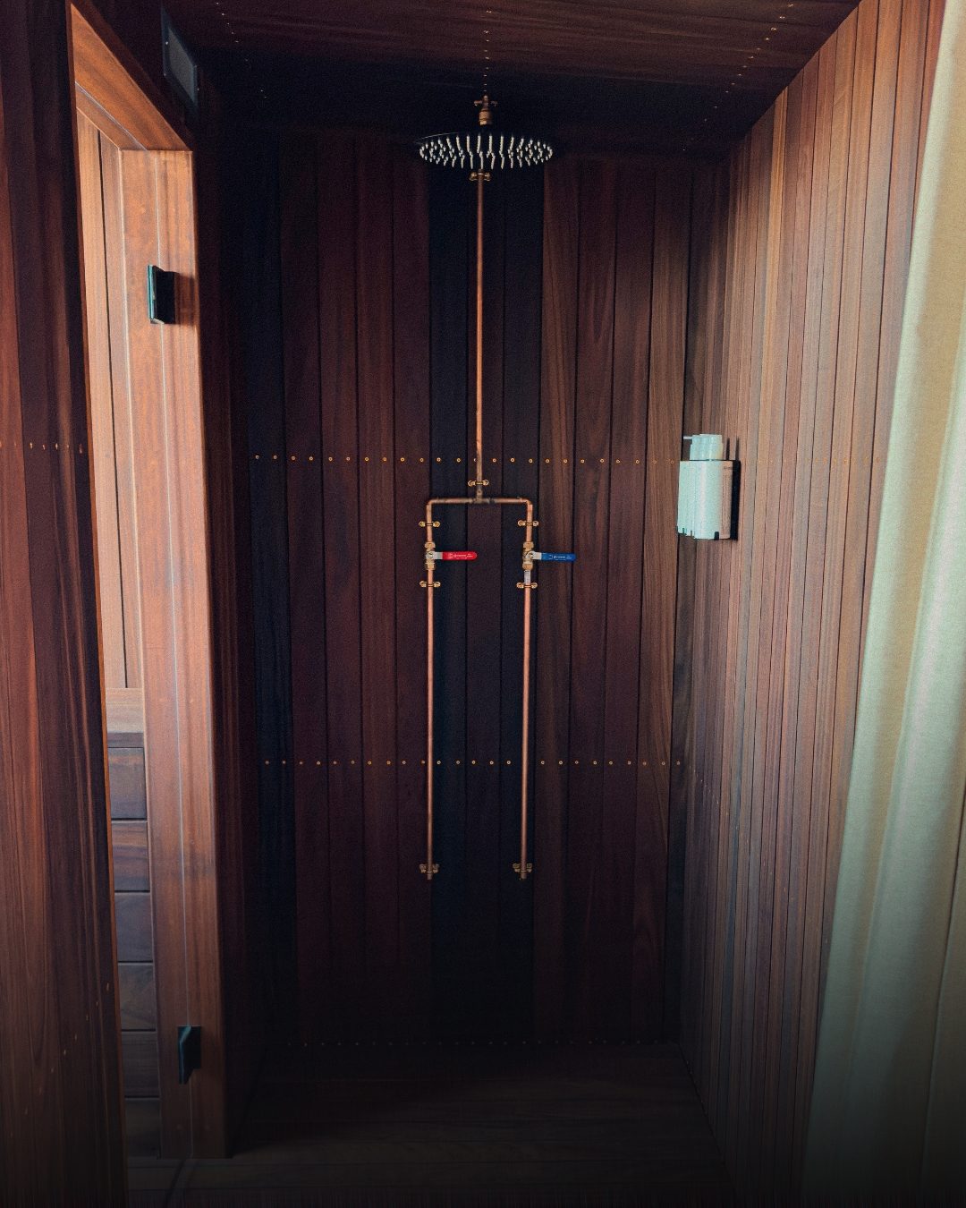 Timber-lined outdoor shower with copper pipework